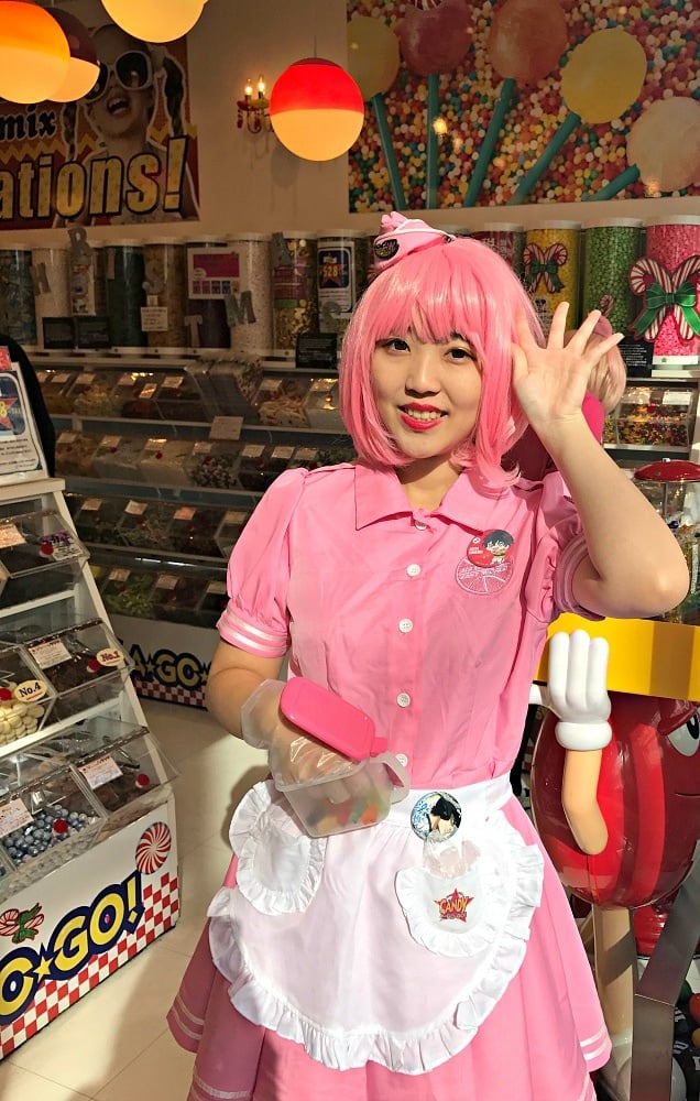 A "Harajuku girl" passing out sweet tastes at a candy shop on Takeshita Street ~ Fun Things to Do in Tokyo with Kids