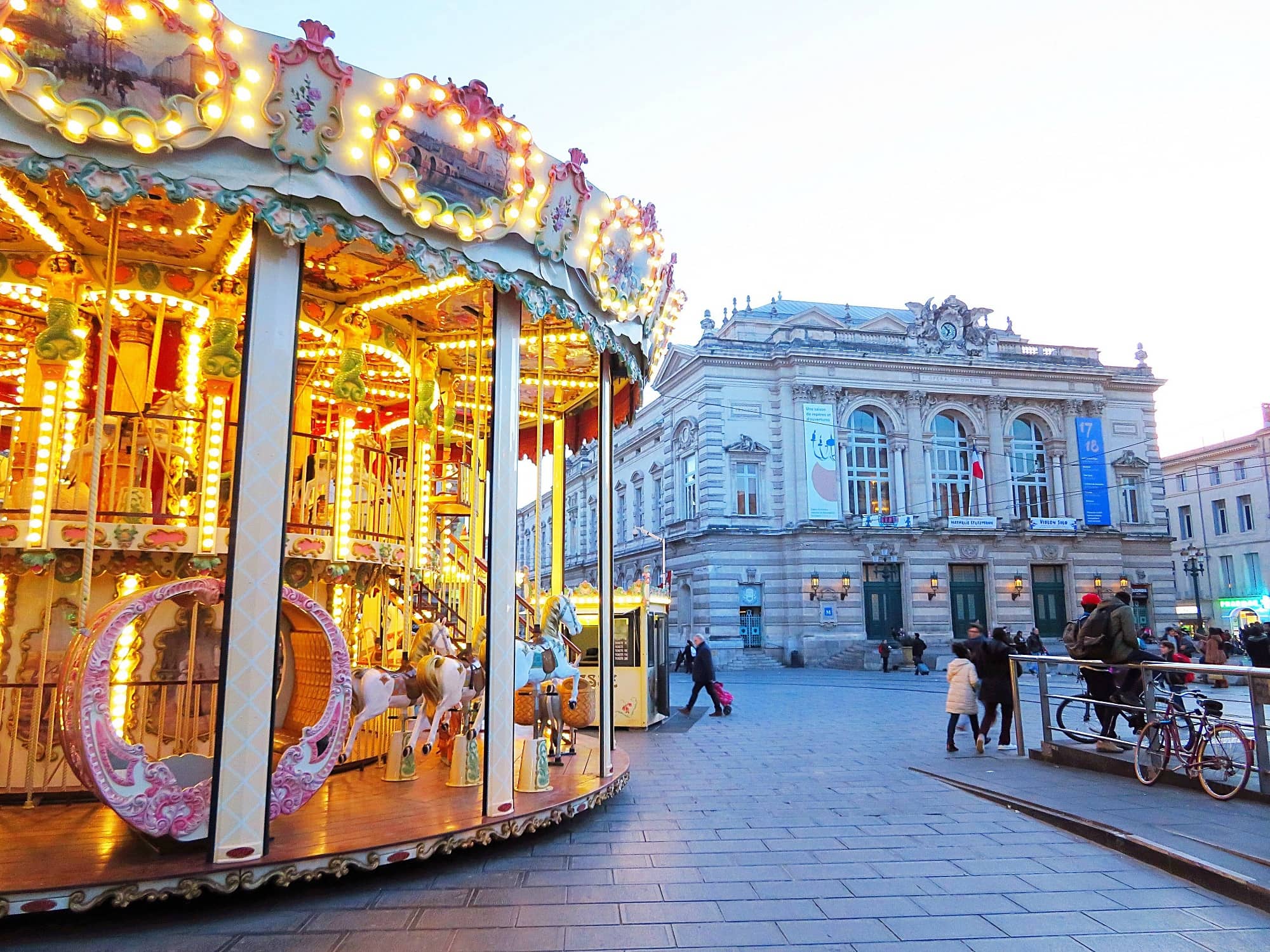 The carousel and opera house on La Place de la Comedie in Montpellier with kids