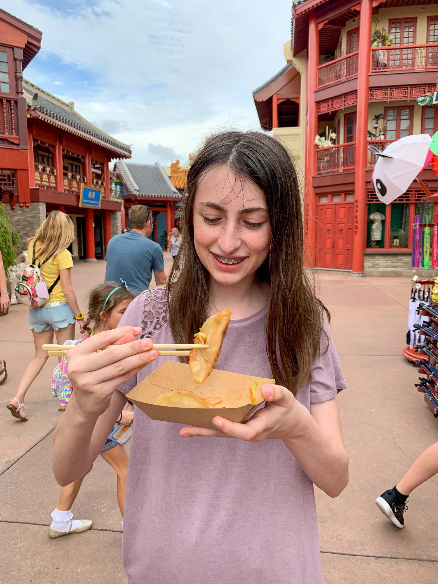 Teen eating dumplings in the China Pavilion at Epcot