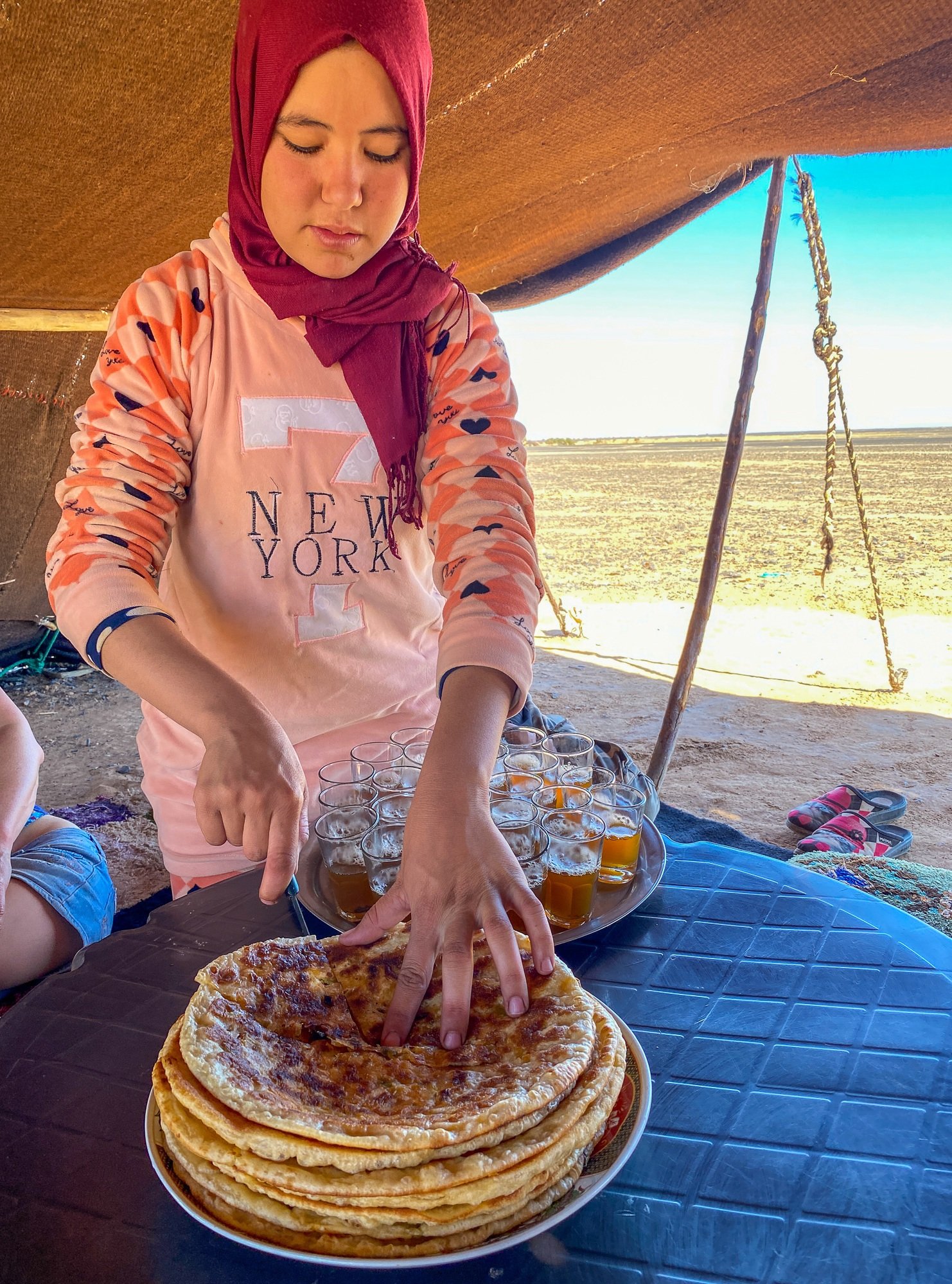 Nomadic Berber teen serving bread to guests