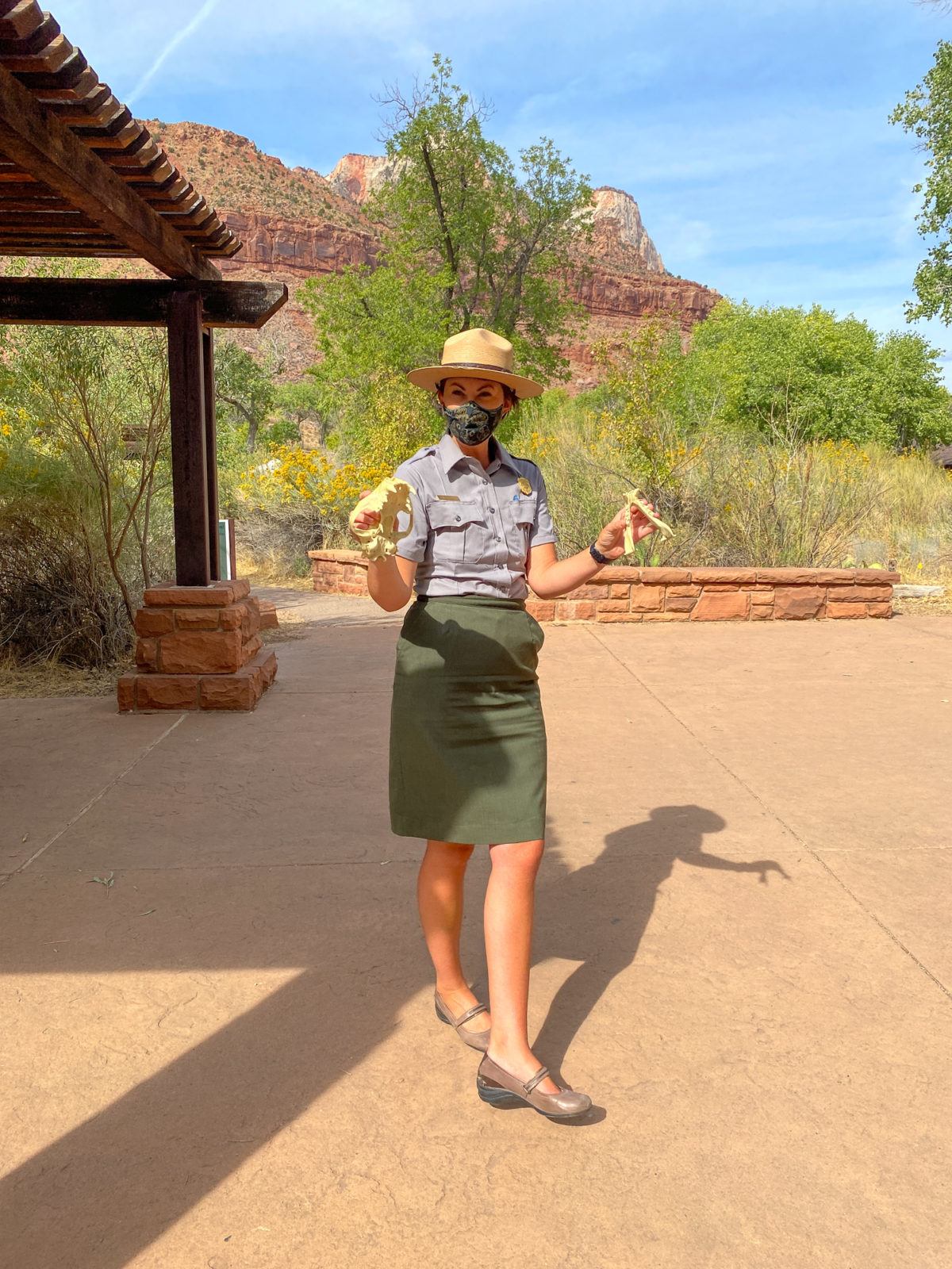 A Zion National Park Ranger showing park goers a mountain lion skull while they wait in line for shuttle tickets 