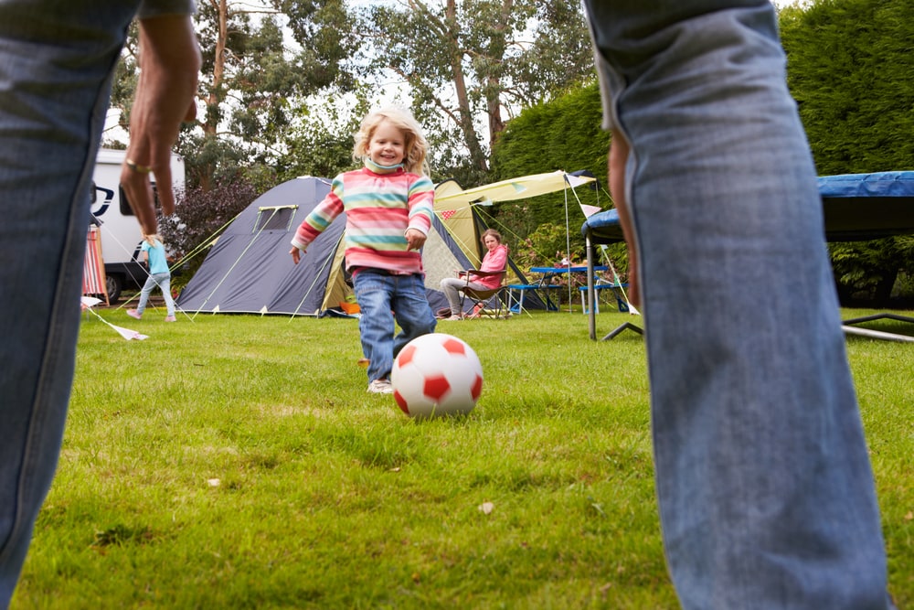 Playing soccer with children during camping trip