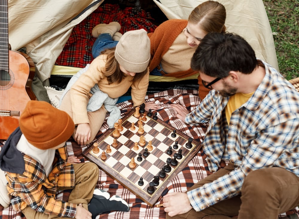Family playing chess outdoors
