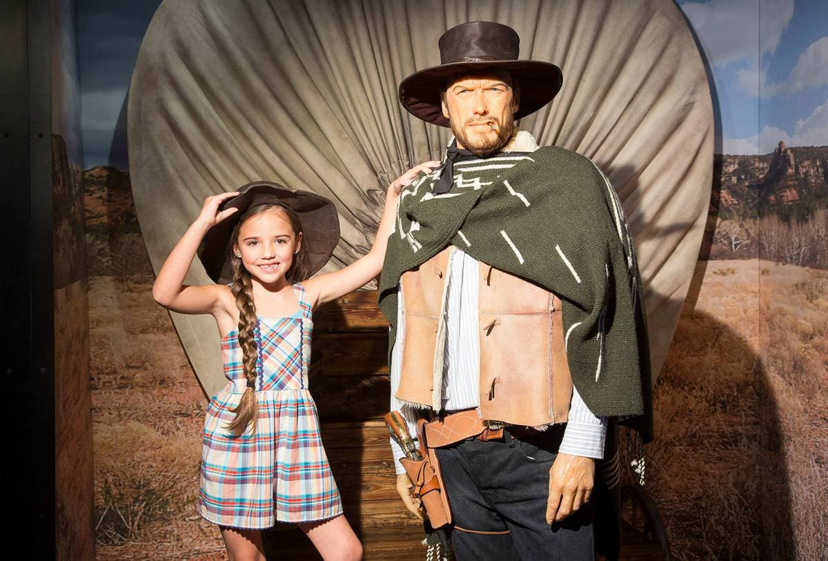 Child posing with Clint Eastwood's wax figure at Myrtle Beach's Hollywood Wax Museum