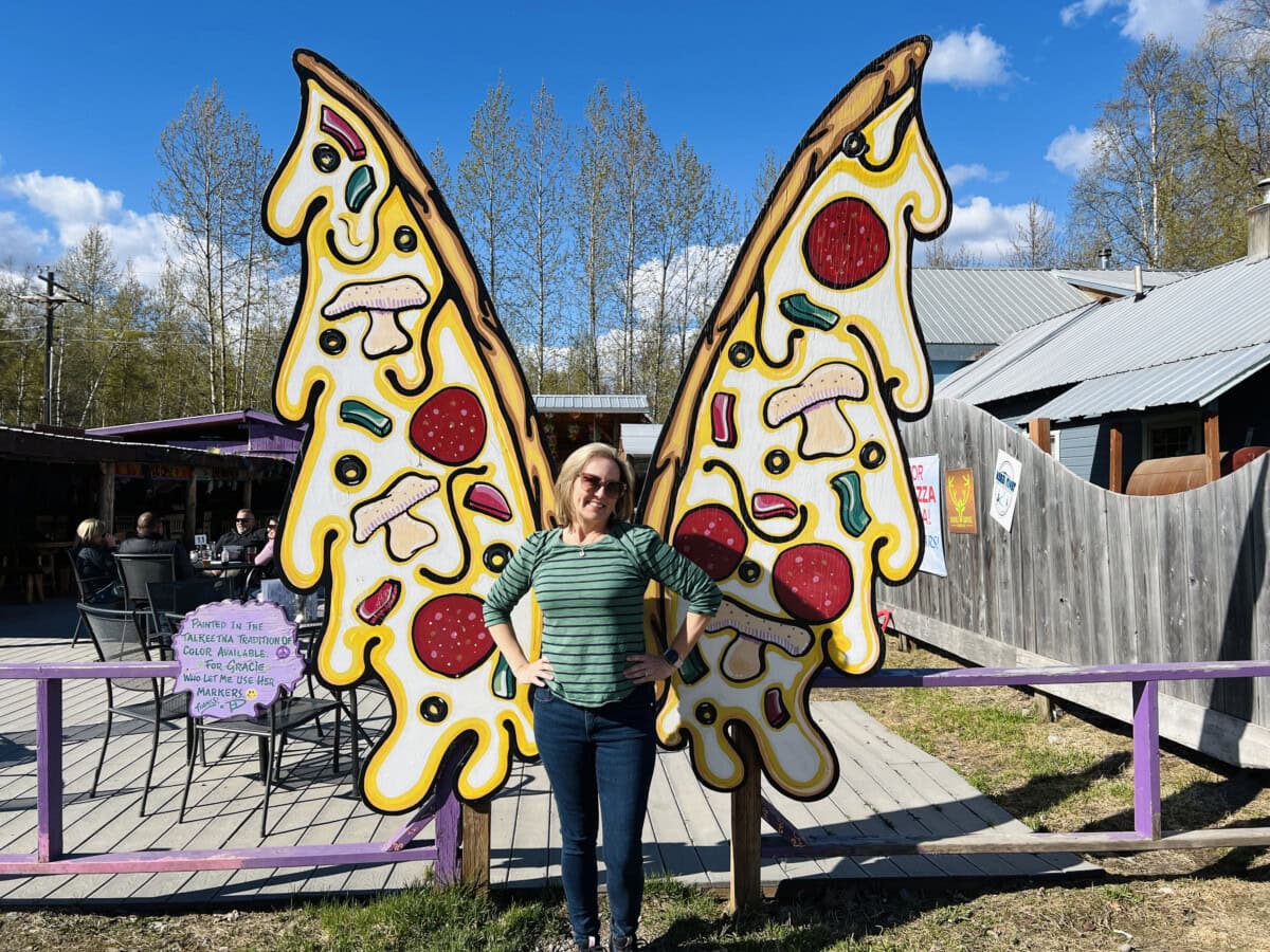 Colleen Lanin posing with  pizza wings at Mountain High Pizza Pie